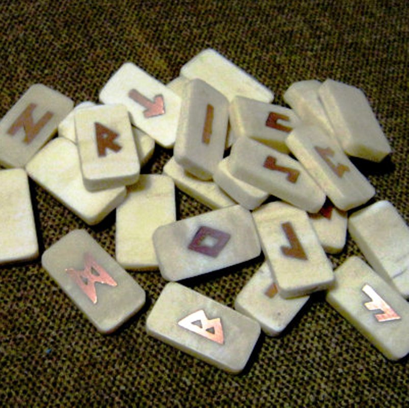 Bone and copper elder futhark runes. Bone runes