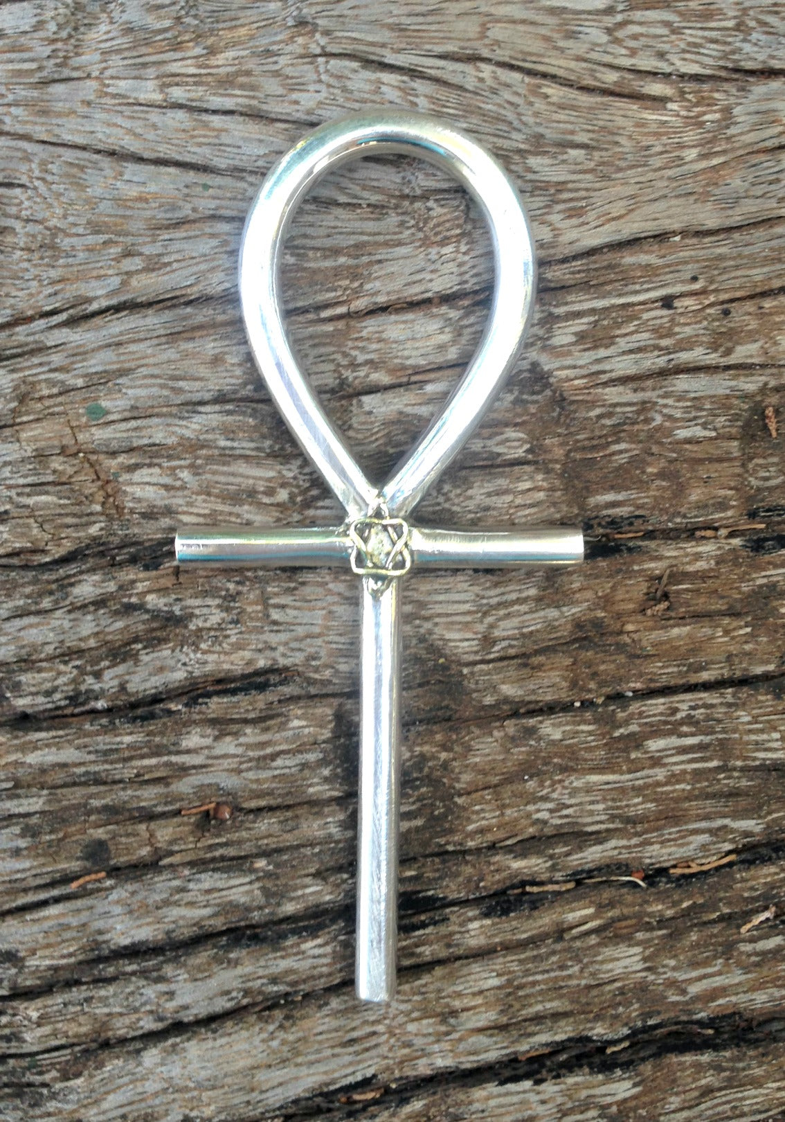 silver ankh with merkebar photographed on African wood